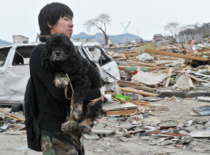 Japan, Tsunami, Earthquake, Man carrying dog Japan, Tsunami, Earthquake, Man carrying dog